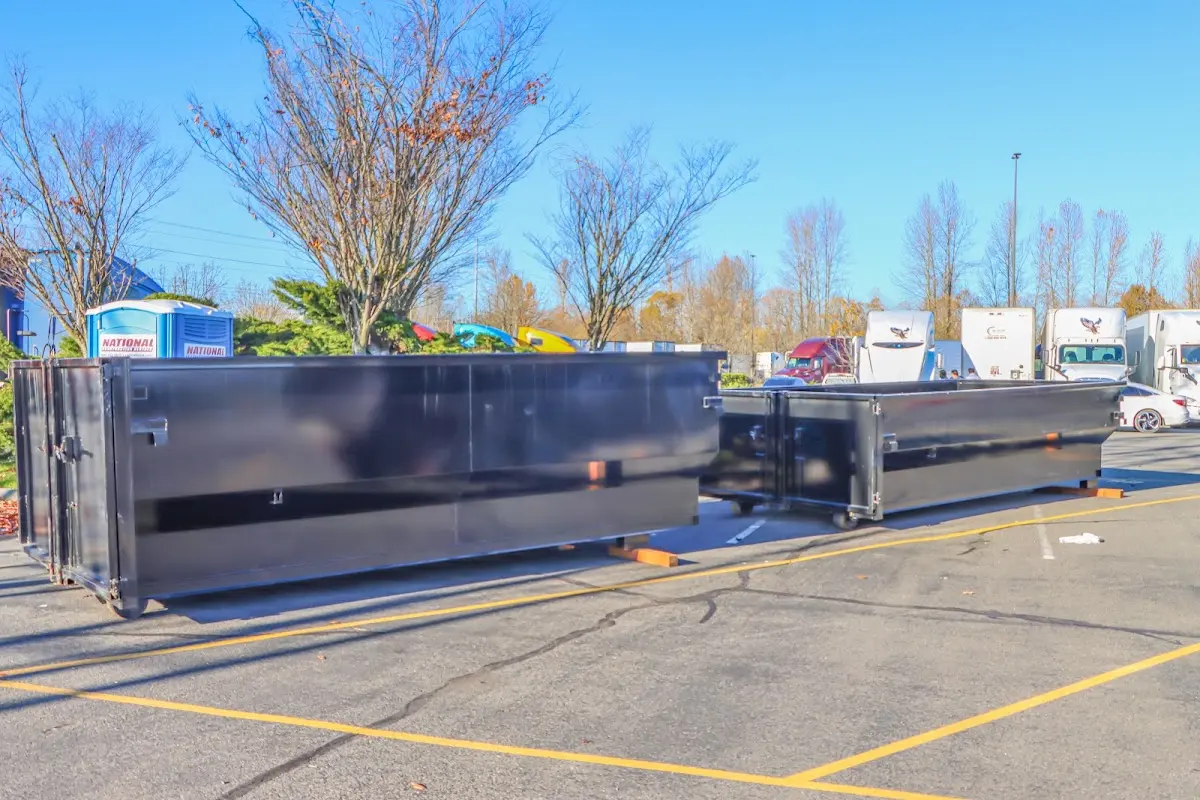 Professional dumpster rental service with roll-off container on residential driveway in East Lansing